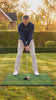 Golfer hitting a driver off the YardRange hitting mat in a garden